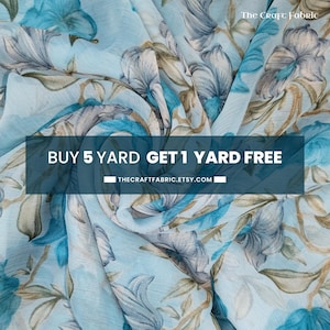 Puede incluir: Tela de gasa azul con estampado floral sobre fondo blanco. La tela es ligera y aireada, perfecta para crear prendas, accesorios y decoración del hogar. Compra 5 yardas y obtén 1 yarda gratis en thecraftfabric.etsy.com.