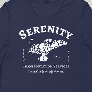 May include: A navy blue t-shirt with a white graphic of a spaceship with the text "SERENITY ESTD 2517 TRANSPORTATION SERVICES You can't take the sky from me."
