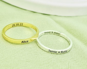 Op de afbeelding: Twee dunne gouden en zilveren ringen met gegraveerde tekst. De gouden ring heeft de tekst "29.10.22 Alice" en de zilveren ring heeft de tekst "forever & always Jamie ♥ Ruby".
