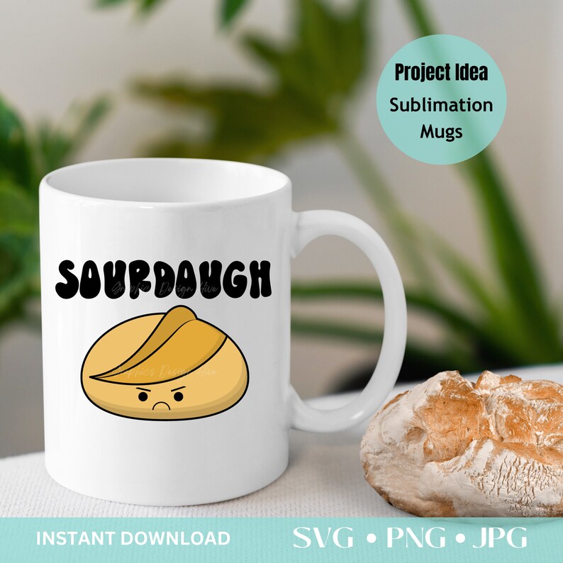 Pode incluir: Caneca de cer&acirc;mica branca com a palavra "SOURDOUGH" em letras pretas e em negrito. Abaixo, uma ilustra&ccedil;&atilde;o de desenho animado de um p&atilde;o com uma cara carrancuda. A caneca tem uma al&ccedil;a curva e est&aacute; ao lado de um p&atilde;o.