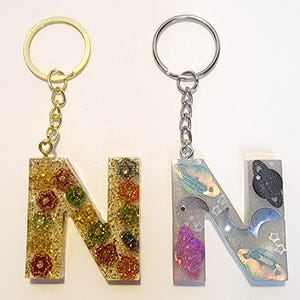Chaveiro com letra N de glitter de resina - 1 1/2 x 1 1/2 polegada com gemas douradas e tema de galáxia espacial