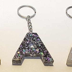 Chaveiro com letra A de glitter de resina - 1 1/2 x 1 1/2 polegada de gema dourada, bolinhas roxas e tema de galáxia espacial