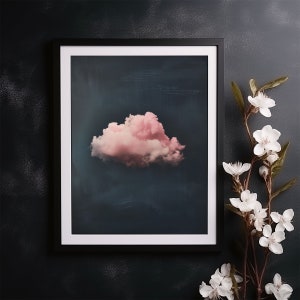 May include: A framed print of a single pink cloud against a dark blue background.