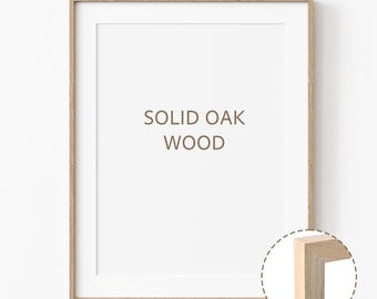 May include: A natural wood picture frame with a white mat and the text "SOLID OAK WOOD" printed in brown. The frame is shown with a close-up of the corner to highlight the wood grain.
