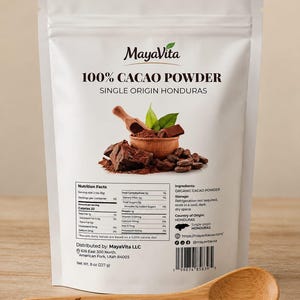 May include: A white stand-up pouch of MayaVita 100% Cacao Powder from Honduras, featuring a nutrition facts label, a graphic of cacao beans and a wooden bowl, and a wooden spoon with the text MayaVita 100% Cacao printed on the handle.