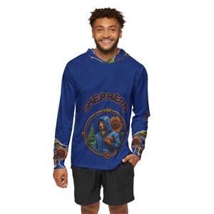 May include: A long-sleeved blue hoodie with a graphic of a dog wearing a hoodie and holding a football, surrounded by sunflowers. The word "SHEPHERD" is arched above the graphic. The sleeves have sunflower and nature-themed designs.