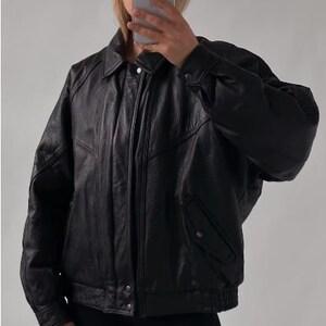 May include: A black leather bomber jacket with a zipper closure and a stand-up collar.