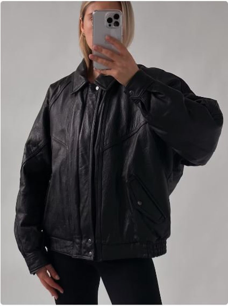 May include: A black leather bomber jacket with a zipper closure and a stand-up collar.