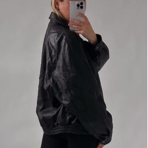 May include: A black leather jacket with a zipper closure and a stand-up collar.
