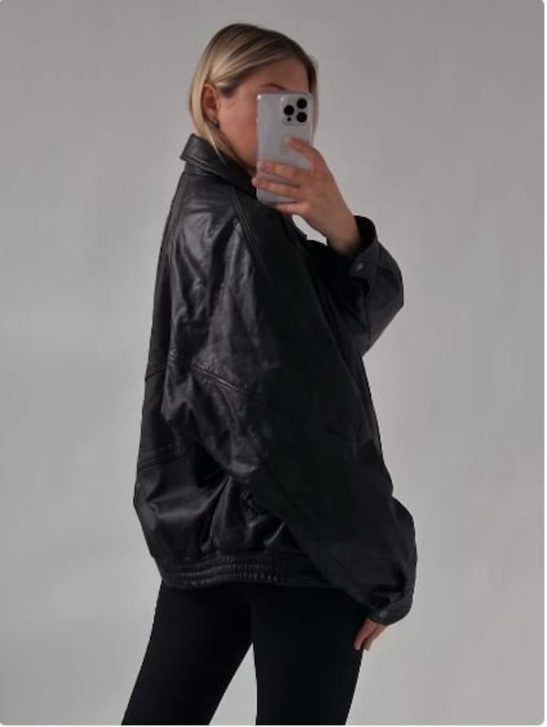 May include: A black leather jacket with a zipper closure and a stand-up collar.