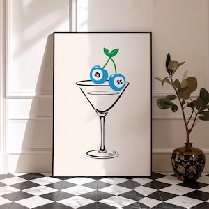Puede incluir: Una impresión artística enmarcada que presenta una copa de martini con dos cerezas azules. Cada cereza tiene un número, 23 y 55. Las cerezas tienen tallos y hojas verdes. El fondo es blanco y el marco es negro.