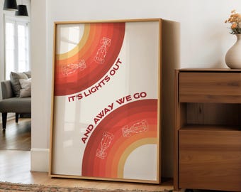 May include: Framed art print with a retro design featuring a rainbow of orange and red hues. The print includes stylized race cars and the text "IT'S LIGHTS OUT AND AWAY WE GO". The artwork is displayed in a wooden frame.