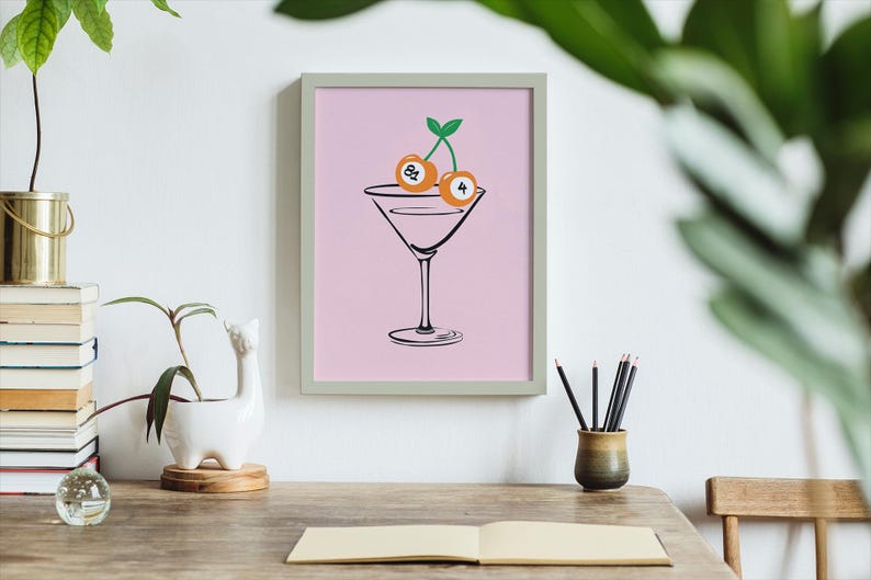 May include: A pink framed print with a black line drawing of a martini glass with two cherries on top. The cherries are numbered 8 and 4.