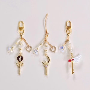 Ciondolo per telefono a forma di luna con ragazza magica kawaii – Cinturino da polso con perline a forma di cuore iridescente e Sakura, accessorio ispirato agli anime, grazioso regalo per lei