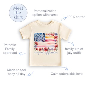 Puede incluir: Camiseta color crema con un dise&ntilde;o de bandera americana en acuarela y detalles florales. La bandera incluye estrellas de margaritas azules, rayas rojas y rosas, y el texto "250 years of freedom". 100% algod&oacute;n.