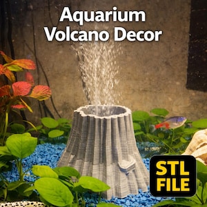 Könnte beinhalten: Graue Aquarium-Vulkan-Dekoration mit Wasser, das aus der Spitze ausbricht. Der Vulkan ist von grünen Pflanzen, blauem Kies und einem kleinen Fisch umgeben. Der Text "Aquarium Volcano Decor" steht oben, und "STL FILE" steht unten rechts.