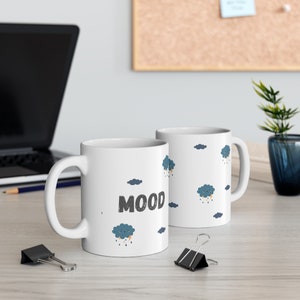 May include: Two white ceramic mugs with a black and white cloud design. One mug has the word "MOOD" printed on it.