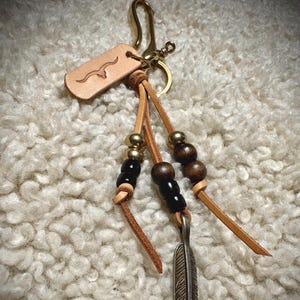 Handmade laced brass key clip or Japanese fish hook. Assorted beads.  Feather pendant.