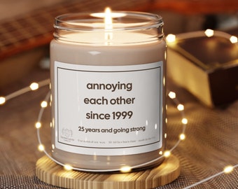May include: A brown candle with a white label that reads "annoying each other since 1999 25 years and going strong".
