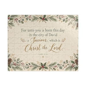 Puede incluir: Un rompecabezas rectangular con fondo crema y un borde de ramas de pino verdes, bayas rojas y piñas. El texto dice: For unto you is born this day in the city of David a Saviour, which is Christ the Lord. Luke 2:11.