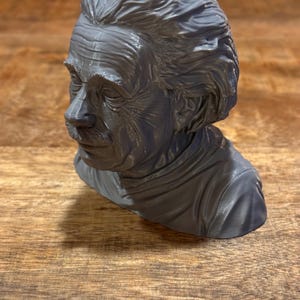 Op de afbeelding: Een grijs 3D-geprint buste van Albert Einstein. De buste toont Einsteins gezicht en haar in detail.