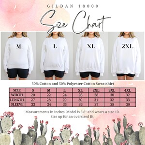 Op de afbeelding: Maattabel voor witte sweatshirts met afmetingen in inches. De tabel bevat maten S tot en met 4XL, met een breedte vari&euml;rend van 50,8 tot 81,3 cm en een lengte van 68,6 tot 83,8 cm. Het model is 1,73 m lang en draagt maat 10.