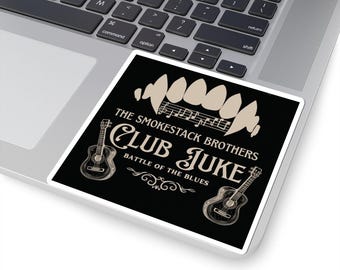 Puede incluir: Una pegatina cuadrada negra con el texto "THE SMOKESTACK BROTHERS CLUB JUKE BATTLE OF THE BLUES" en blanco y beige. La pegatina incluye ilustraciones de guitarras y notas musicales. La pegatina está colocada en un portátil.