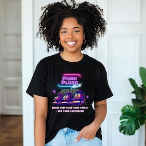 May include: Black t-shirt with a neon graphic of the words "Pork Plaza Mall" and three futuristic vehicles. The text below reads "WHERE THEY SLASH THEIR PRICES - AND THEIR CUSTOMERS!"