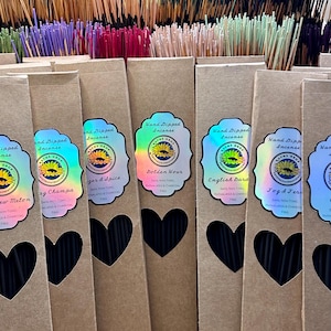 May include: A variety of incense sticks in brown cardboard boxes with heart-shaped cutouts. The boxes have labels with the text "Hand Dipped Incense" and different scents, including "Golden Hour", "English Garden", "Jogd & Ferns", "Ginger & Spice", "Nag Champa", and "New Melon".