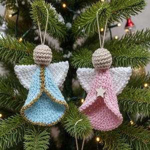 以下が含まれることがあります： クリスマスツリーに飾られた、手作りのかぎ針編み天使オーナメント2つ。1つは金色のトリムが付いた水色、もう1つは木の星が付いたピンク色です。どちらも白い翼とベージュの頭があります。お祝いのホリデーデコレーション。