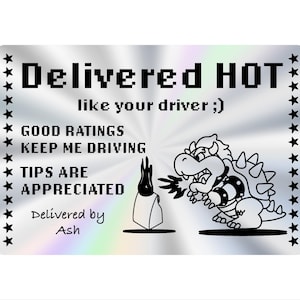 May include: A silver sticker with black text that reads "Delivered HOT" and "like your driver ;)". It features a cartoon dragon breathing fire and the text "GOOD RATINGS KEEP ME DRIVING TIPS ARE APPRECIATED".