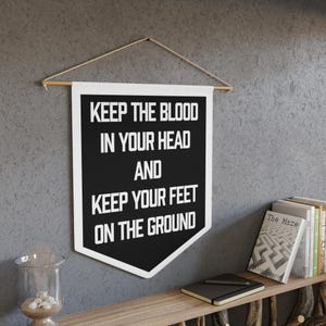 May include: Black and white pennant banner with the text "Keep the blood in your head and keep your feet on the ground".