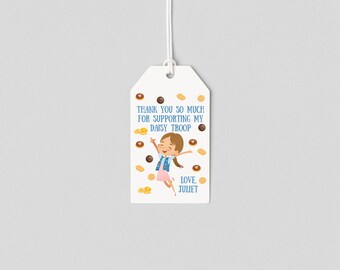 May include: White tag with a girl scout in a blue vest jumping with her arms raised. The tag says "Thank you so much for supporting my Daisy Troop. Love, Juliet" and is surrounded by images of Girl Scout cookies.