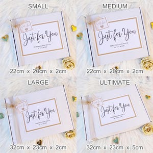 以下が含まれることがあります： Small、Medium、Large、Ultimateとラベル付けされた4つの白い長方形のギフトボックス。各ボックスには、金色の縁取りが施されたラベルがあり、Just for You、Personalised Gifts by Kay Blumeというテキストと、ハートのアイコンが付いたWith Loveという小さなタグが付いています。
