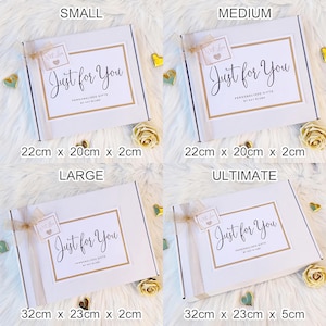 K&ouml;nnte beinhalten: Vier wei&szlig;e rechteckige Geschenkboxen mit der Beschriftung Small, Medium, Large und Ultimate. Jede Box hat ein gold umrandetes Etikett mit dem Text Just for You, Personalised Gifts by Kay Blume und einen kleinen Anh&auml;nger mit With Love.