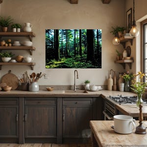 May include: A rectangular wall art print featuring a dense forest scene with tall dark tree trunks and bright green foliage on the ground. The print is displayed on a beige kitchen wall above a sink, surrounded by wooden shelves, kitchenware, and plants.