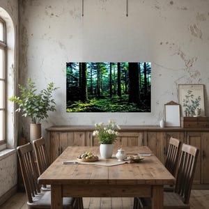 May include: A rectangular wall art print featuring a dense forest scene with tall dark tree trunks and vibrant green mossy ground. The artwork is displayed on a light-colored wall above a wooden dining table set with a vase of white flowers.