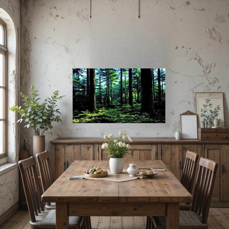 May include: A rectangular wall art print featuring a dense forest scene with tall dark tree trunks and vibrant green mossy ground. The artwork is displayed on a light-colored wall above a wooden dining table set with a vase of white flowers.