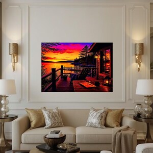 May include: A rectangular wall art print depicting a sunset over a lake from a wooden deck. The scene features a vibrant orange and purple sky, a silhouette of pine trees, a wooden chair, a table with an open book, and a glowing lantern.