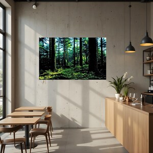 May include: A rectangular wall art print featuring a dense forest scene with tall dark tree trunks and vibrant green foliage illuminated by sunlight. The artwork is displayed on a light gray concrete wall above a wooden counter and dining area.