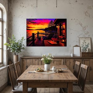 May include: A rectangular wall art print depicting a sunset over a lake from a wooden deck. The scene features a chair, a table with a book and lantern, and a vibrant sky with orange, pink, and purple hues above a dark forest silhouette.