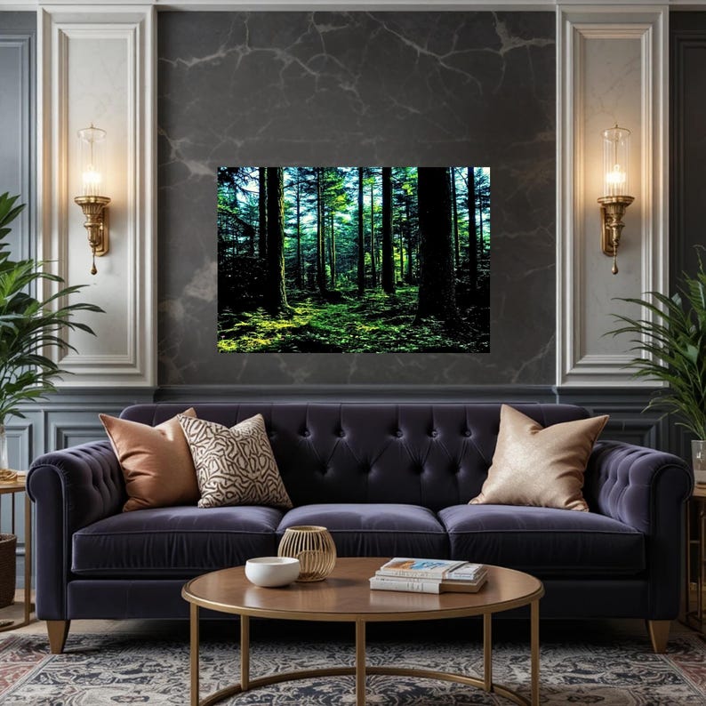 May include: A rectangular wall art print depicting a dense forest scene with tall dark tree trunks and vibrant green foliage illuminated by sunlight, displayed above a dark purple tufted sofa with two beige pillows and a round wooden coffee table.