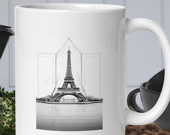 May include: White ceramic mug featuring a black and white illustration of the Eiffel Tower. The tower is depicted in a minimalist style with a geometric design.