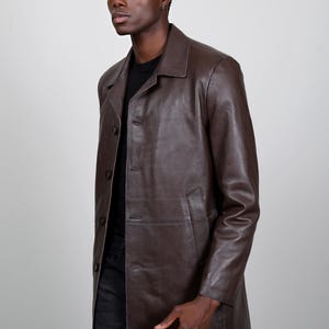 May include: A brown leather jacket with a button-up front and long sleeves.