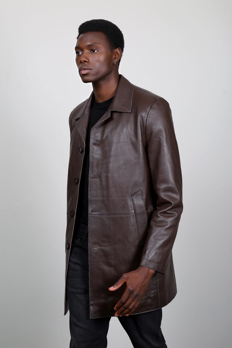 May include: A brown leather jacket with a button-up front and long sleeves.