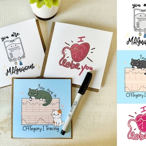 May include: Four greeting cards with different designs. The first card features a cartoon IV bag with the text "You are MAgnificent". The second card features a cartoon heart with the text "I lobe you". The third card features a cartoon cat EKG with the text "You are a CATegory I Tracing". The fourth card features a cartoon heart with the text "I lobe you".