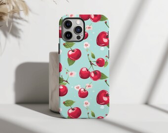 以下が含まれることがあります： 赤いチェリーと白い花のパターンが施された青い携帯電話ケース