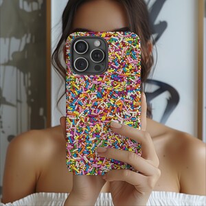 May include: A colourful phone case with a sprinkle pattern. The case is made of a hard plastic material and has a raised camera bump.