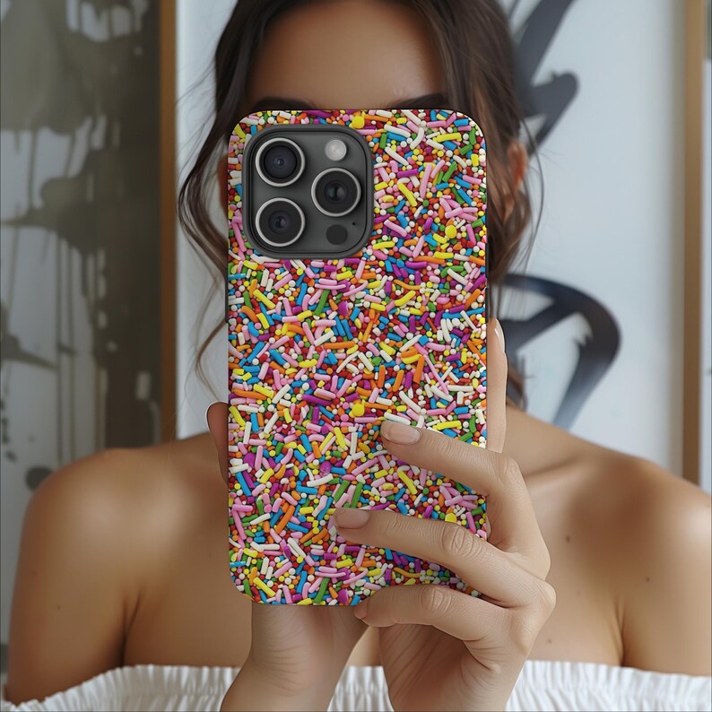 May include: A colourful phone case with a sprinkle pattern. The case is made of a hard plastic material and has a raised camera bump.
