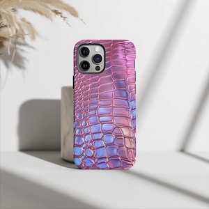 May include: A pink and blue iridescent phone case with a crocodile skin pattern.